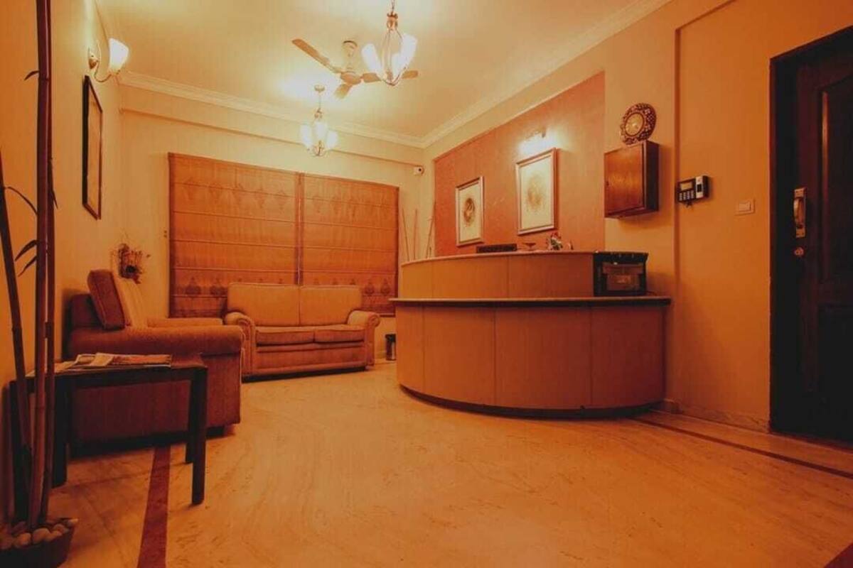 A living room with a sofa, a coffee table, a fireplace, and a wooden cabinet.