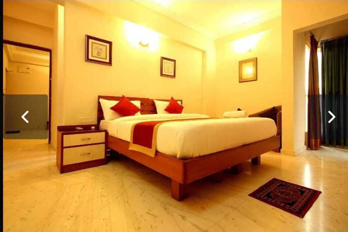 A bedroom with a wooden bed, bedside tables, and a red rug.