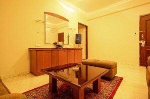 Une pièce comprenant un meuble en bois, une table avec un plateau en verre, un banc rembourré et un tapis à motifs.