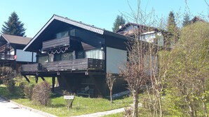 Une maison à deux étages avec un balcon, une allée et une plaque indiquant « Friedbergerweg 19 ».