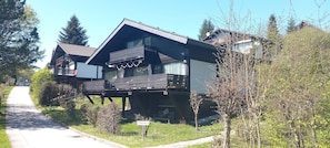 Une maison à deux étages avec un balcon, une allée et une plaque indiquant l’adresse.