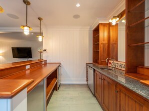 A kitchen with wooden cabinets, a granite countertop, and pendant lighting.