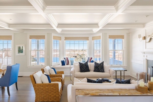 A spacious living room with a large window, a fireplace, and a view of the outdoors.