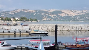 A marina with boats docked, a stone wall, and a bridge in the background. - Tranquil 3-bedroom House in Eğirdir With Stunning Views (Egirdir)