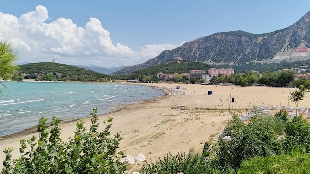 A beach with clear water, a sandy shore, and mountains in the background. - Tranquil 3-bedroom House in Eğirdir With Stunning Views (Egirdir)