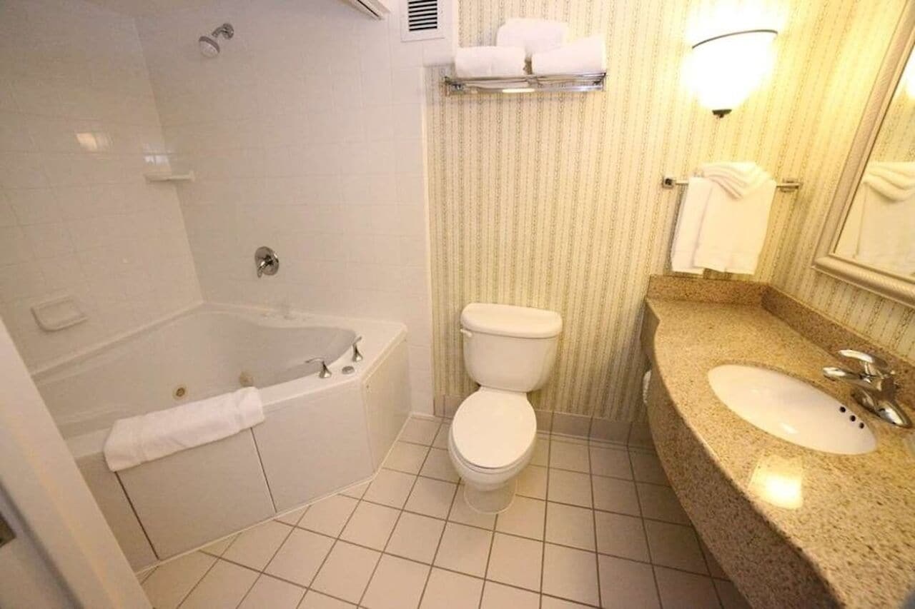 A bathroom with a bathtub, toilet, and sink.