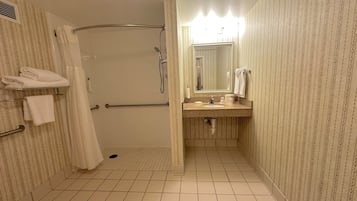 A bathroom with a shower, toilet, and sink.