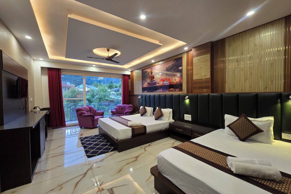 A modern hotel room with a bed, seating area, and a balcony with a view.