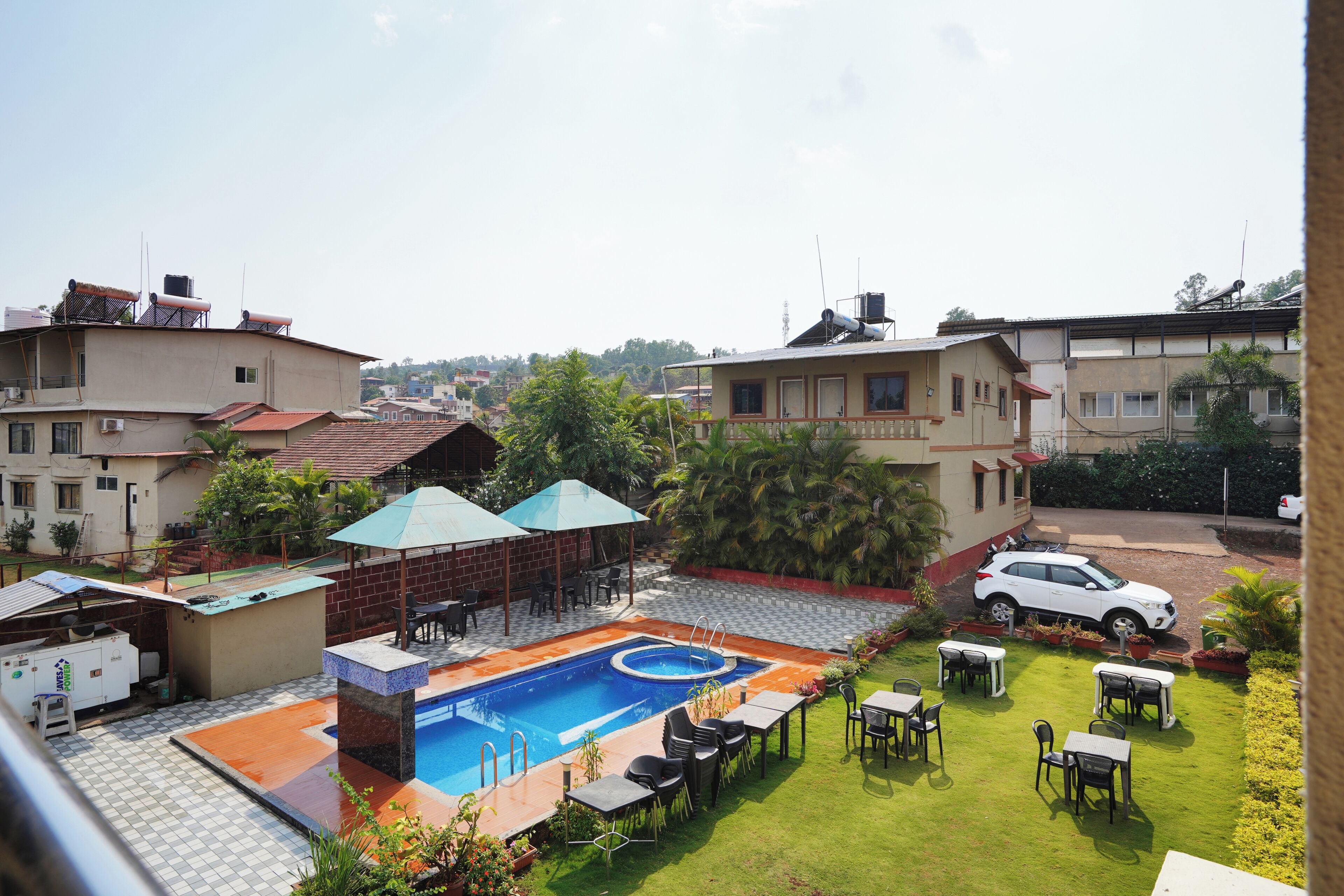 A swimming pool with a sunken center, surrounded by outdoor seating and a lawn.