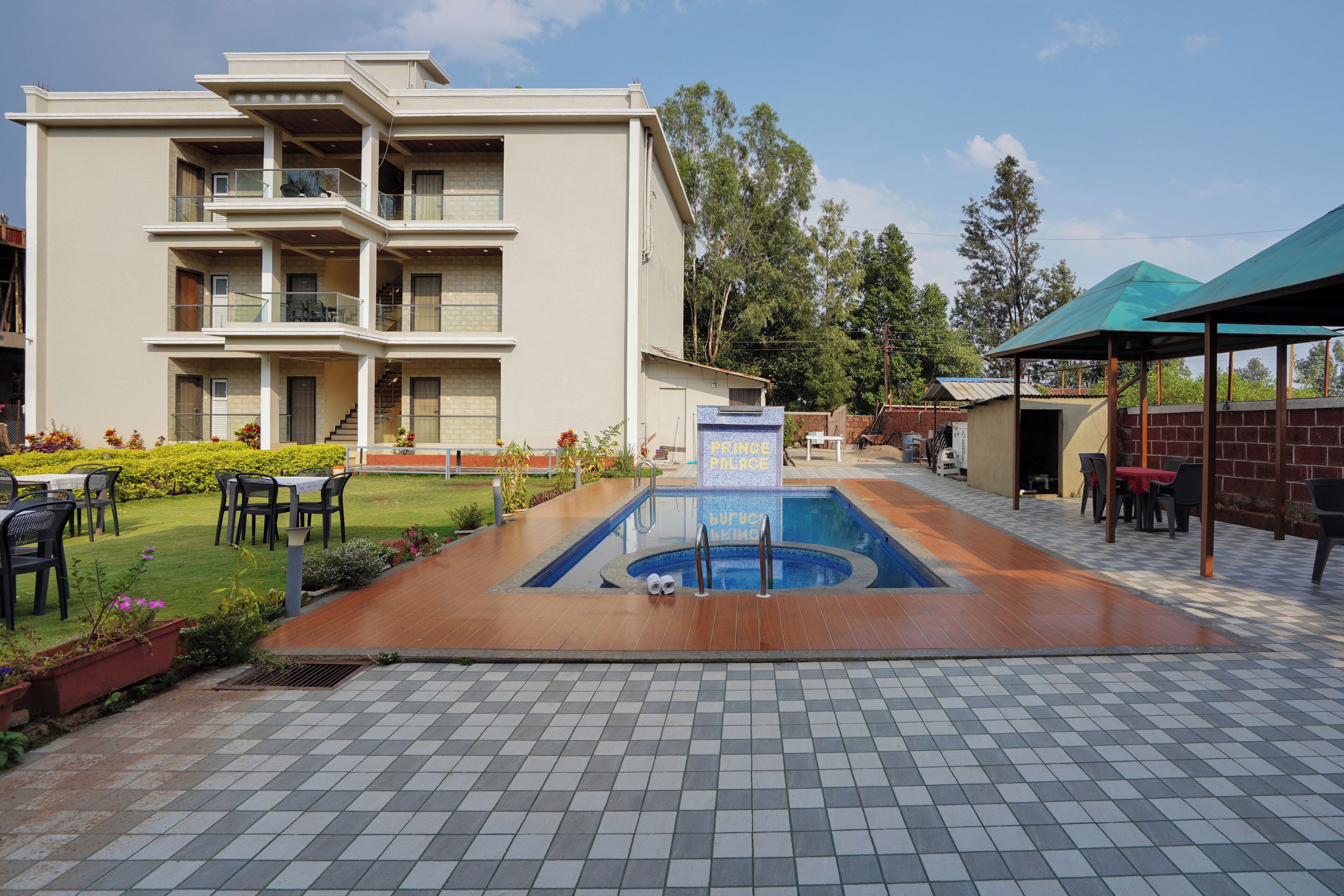 Un hotel de varios pisos con piscina, mobiliario exterior y un letrero que indica un spa.