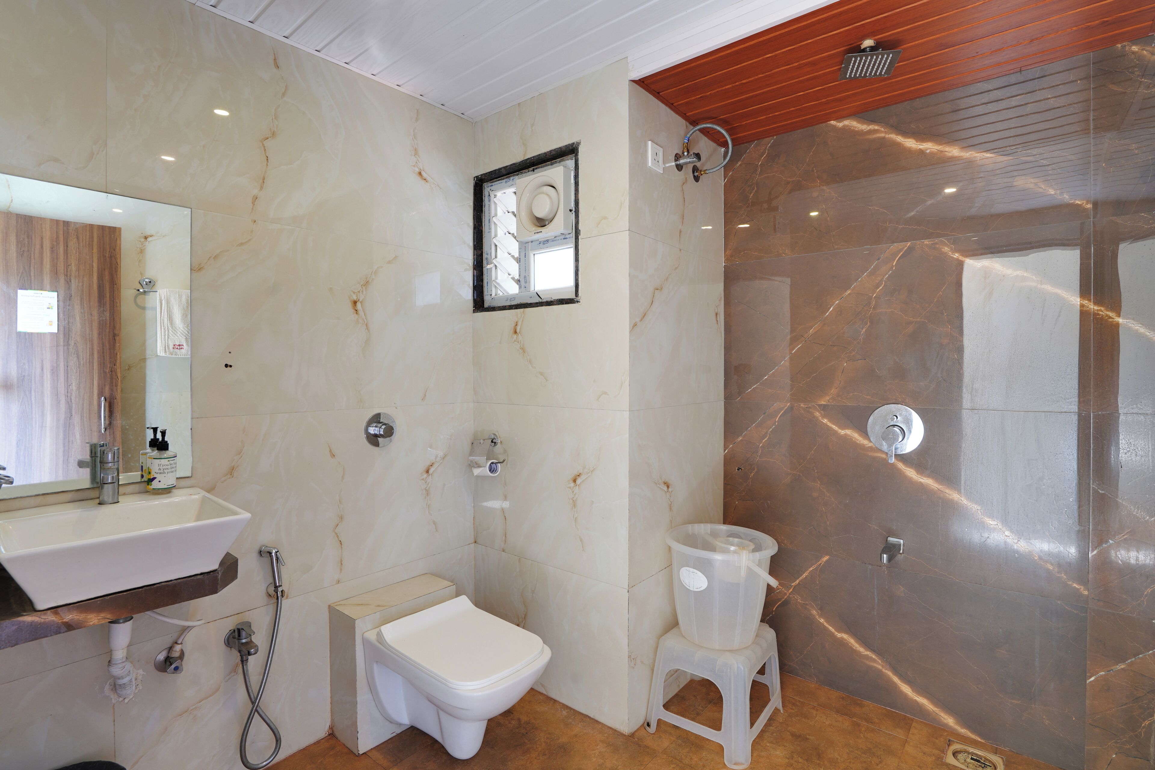 A bathroom with a sink, toilet, shower, and a mirror.