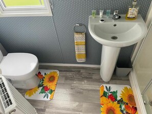 Ein Badezimmer mit Toilette, Waschbecken und Dusche.