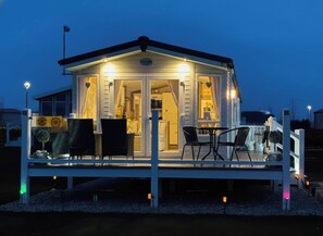 Eine Hütte mit überdachter Terrasse, Essbereich und sichtbarer Küche.