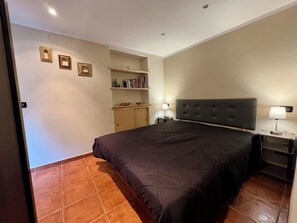 A bedroom with a bed, two bedside tables, a nightstand, a shelf with books, and a wall-mounted shelf. - Accommodation in the center (Torino)