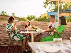 A group of people dining outdoors at a table with a stone wall backdrop. - COZY HOUSE - LODGING 8p LUXURY CAMPING RANGE **** (Lège-Cap-Ferret)