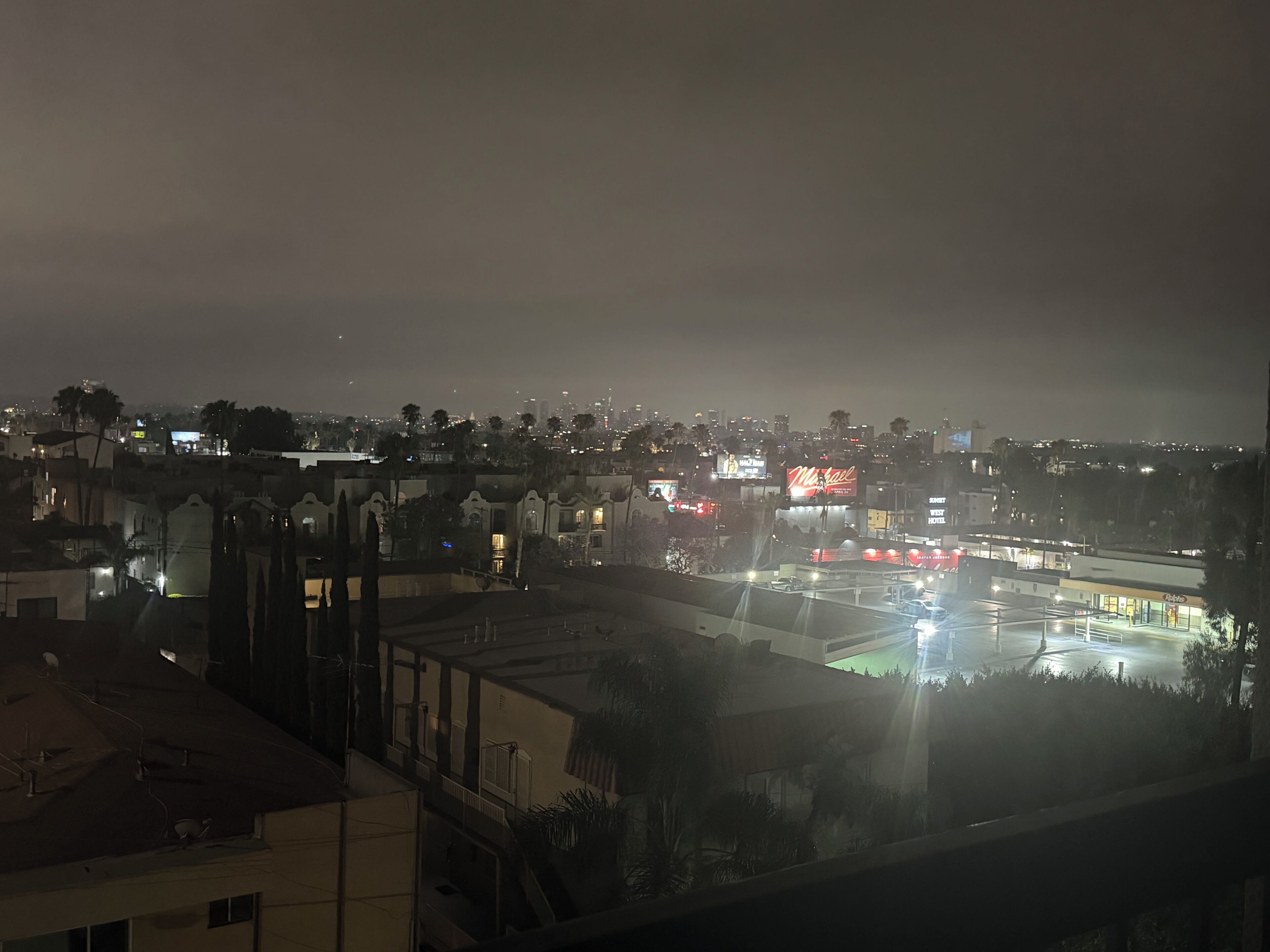A nighttime cityscape with a prominent hotel sign.