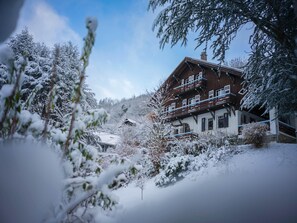 A wooden chalet with multiple balconies, surrounded by snow-covered trees and a clear sky. - Chalet St Gervais les bains 16 pers Les Fiz (Saint-Gervais-les-Bains)