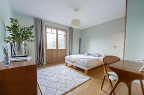 A bedroom with a bed, a desk, a chair, a window with curtains, and a potted plant. - Chalet St Gervais les bains 16 pers Les Fiz (Saint-Gervais-les-Bains)
