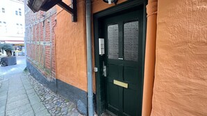 A building with a black door, a small window, and a light fixture above the door. - fewo1846 - Matrosenkoje - fewo1846 - Matrosenkoje - centrally located (Flensburg)