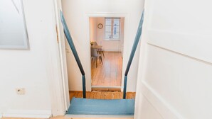 A staircase leading to a dining area with a clock on the wall. - fewo1846 - Sternkoje - fewo1846 - Sternkoje - ideal for a relaxing time out (Flensburg)