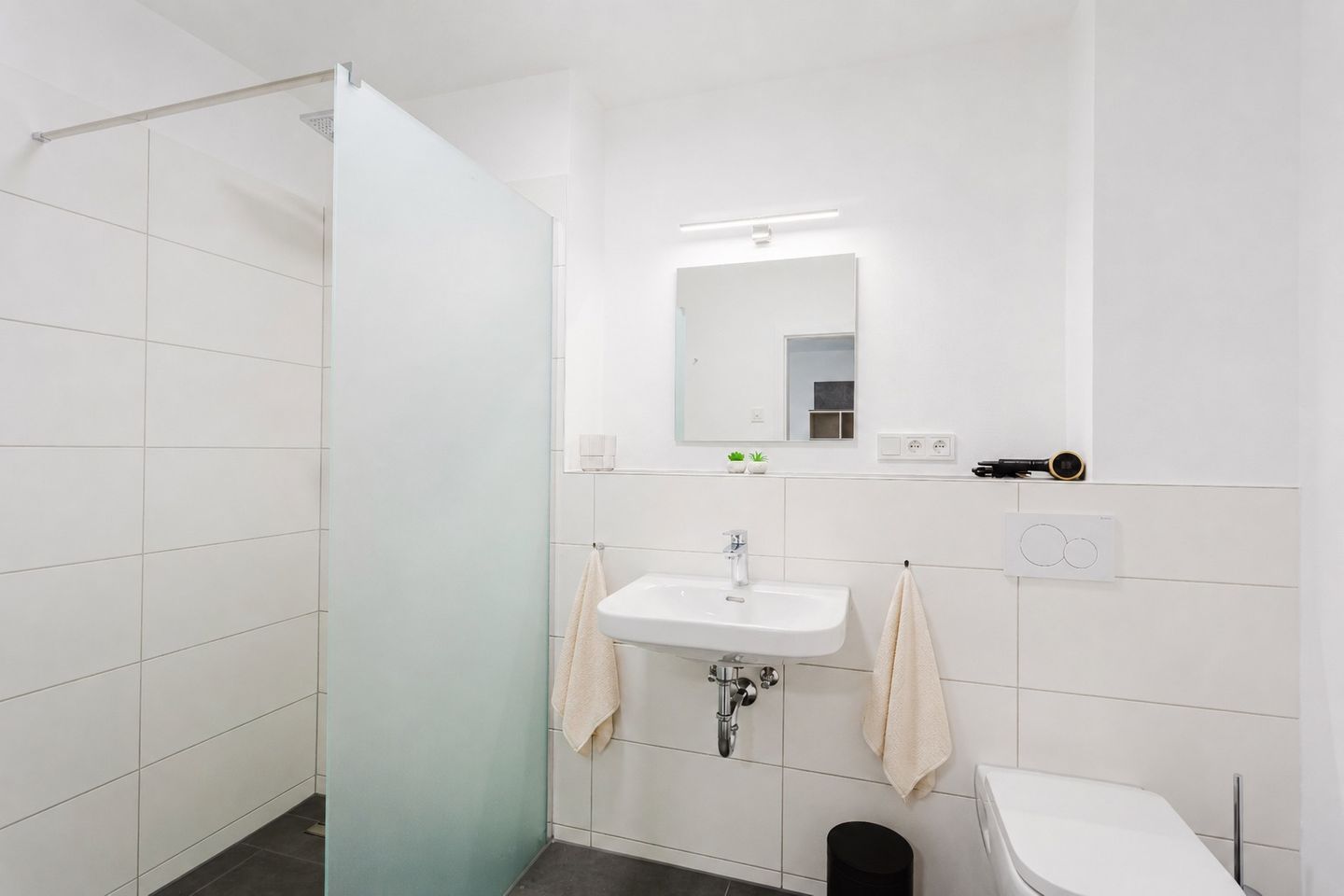 Moderni kylpyhuone, jossa on suihku, pesuallas ja wc.