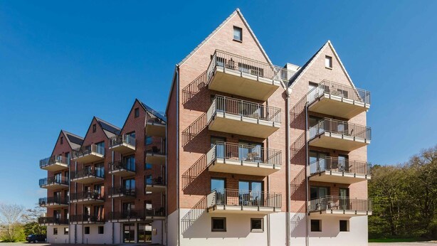 A multi-story residential building with balconies, a brick facade, and a clear sky. - MEERholung Vacation Rental 2.10 1-Raum-Apartment, 400 m from the beach - MEERholung House (Cuxhaven)