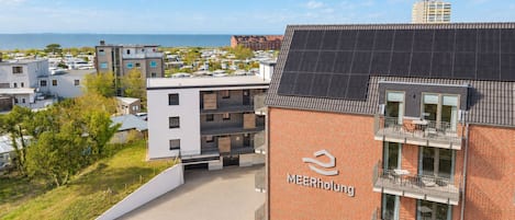 A modern building with a brick facade and a sign reading 'MEERholung'.