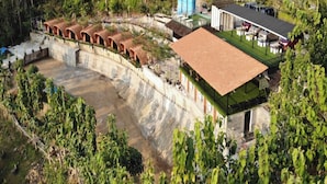 Un resort con piscina, mobiliario exterior y un edificio grande con techo plano.
