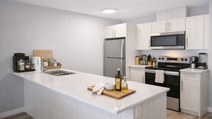 Een moderne keuken met witte kasten, roestvrijstalen apparatuur en een centraal eiland.