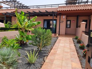 L’entrée d’un hôtel, avec un chemin dallé, une enseigne indiquant « Villa Azul » et un espace abrité agrémenté de plantes.