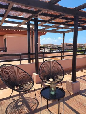A rooftop terrace with two black wire chairs, a small round table, and a glass vase. - Casa Azul, an oasis of peace and tranquility (Lajares)