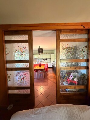 A room with a wooden door leading to a kitchen area. - VILLA MARIA (Castiglione In Teverina)