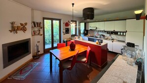 Una cocina moderna con comedor, ventanas amplias y chimenea.