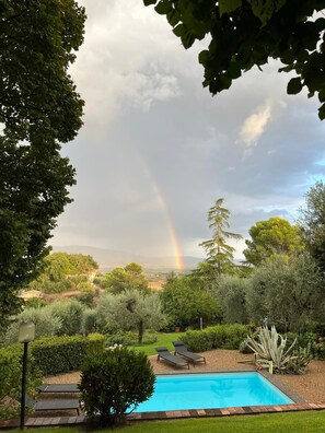 A swimming pool with lounge chairs, surrounded by greenery and a view of distant mountains. - VILLA MARIA (Castiglione In Teverina)