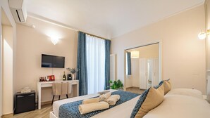 A hotel room with a bed, a desk, a TV, and a mirror. - Relaxation and comfort within walking distance of everything, ideal for families, couples and small groups (Palermo)