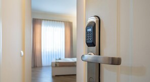 A modern hotel room door with a digital keypad lock, a visible bed, and a window with curtains. - Relaxation and comfort within walking distance of everything, ideal for families, couples and small groups (Palermo)