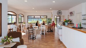 Un restaurante con varias mesas, sillas y una barra.