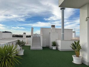 A rooftop terrace with artificial grass, white walls, a metal staircase, and potted plants. - Apartment with rooftop pool 150 m from the beach (03193 San Miguel des Salinas)