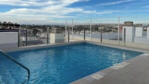 Una piscina en la azotea con vistas despejadas del paisaje urbano.