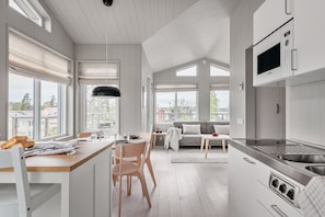 Una cocina moderna con comedor, ventanas amplias y vistas al exterior.