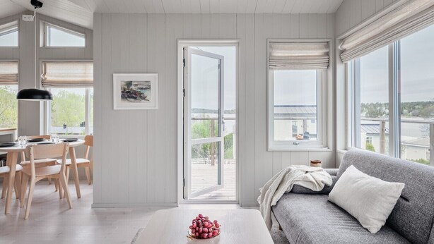 A room with a dining area, a sofa, and a balcony with a view. - Hilltop house overlooking ocean sunrise and sunset (Vaxholm)