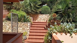A stone staircase leading to a house with a garden.