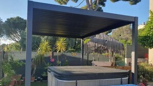 A hot tub under a covered area with steps leading up to it, surrounded by potted plants and a fence. - Room with private Jacuzzi and sea view (Le cannet)