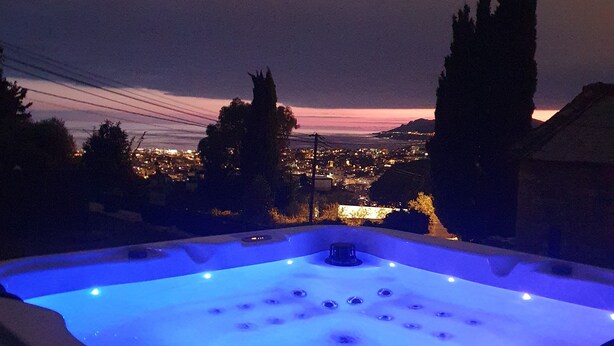 A hot tub with a view of a cityscape at dusk. - Room with private Jacuzzi and sea view (Le cannet)