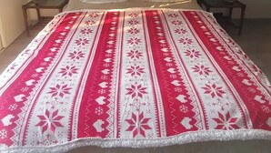 A bed with a red and white patterned bedspread, two white pillows with animal prints, and a curtain with vertical stripes and Chinese characters. - Room with private Jacuzzi and sea view (Le cannet)