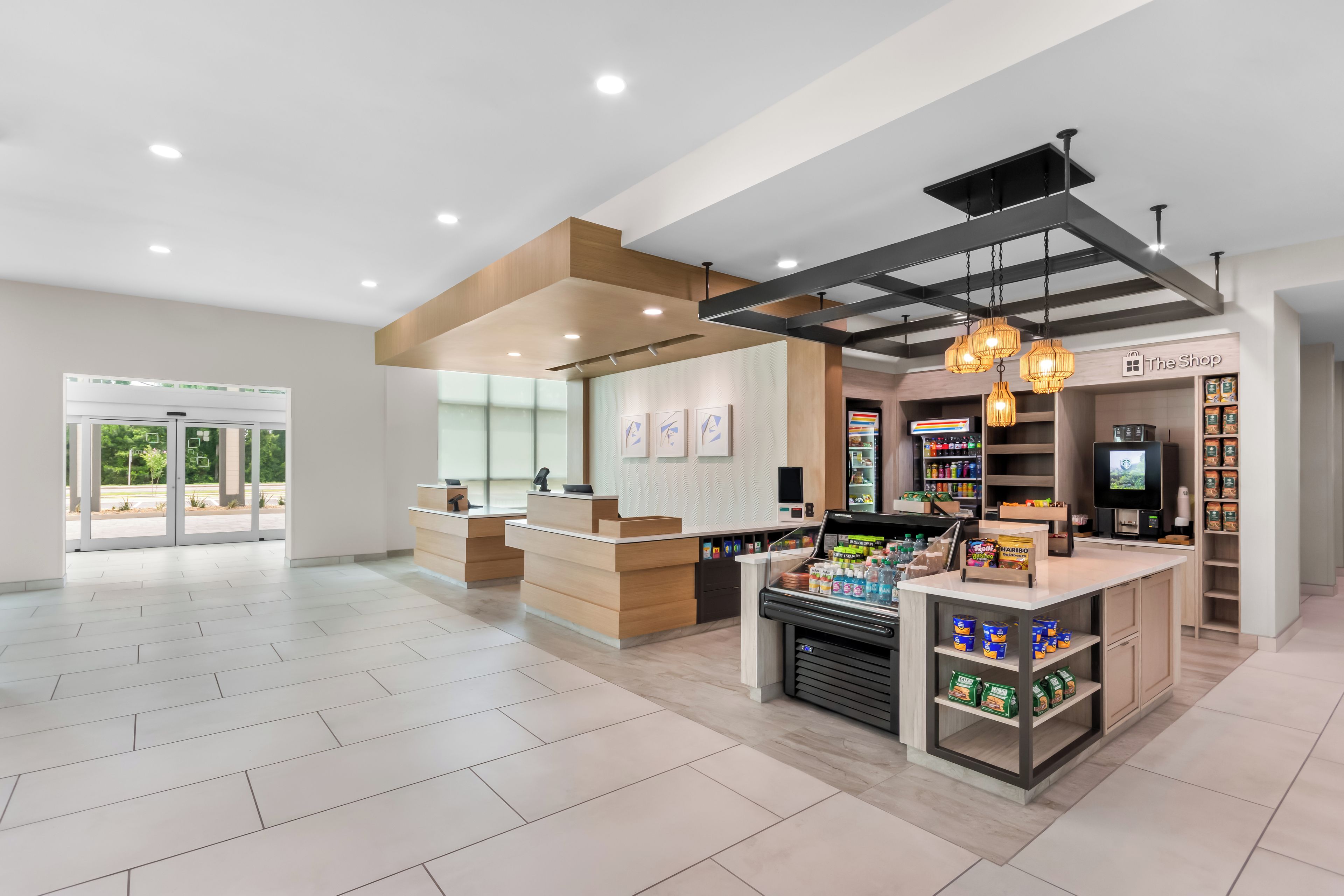 A spacious, modern interior with a reception desk, a coffee station, and a variety of products on shelves.