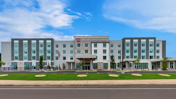 A Hilton Garden Inn hotel with a modern facade, multiple floors, and a well-maintained lawn.