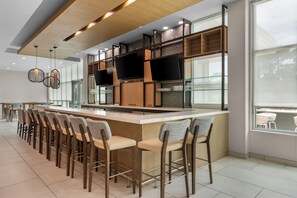 Una cocina moderna con barra, equipada con electrodomésticos de alta gama y un televisor de pantalla plana.