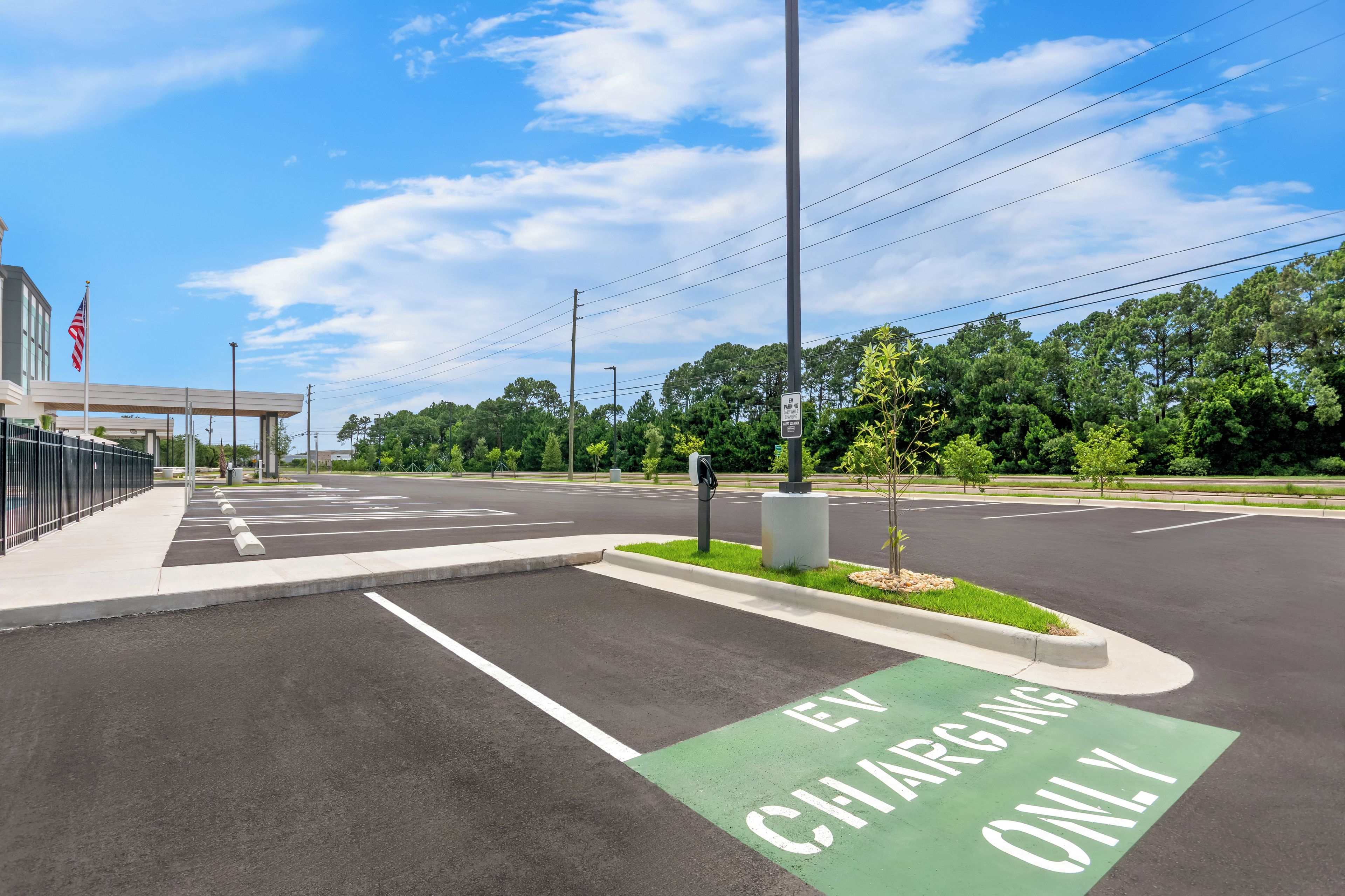A parking lot with EV charging stations and a green EV-only lane.