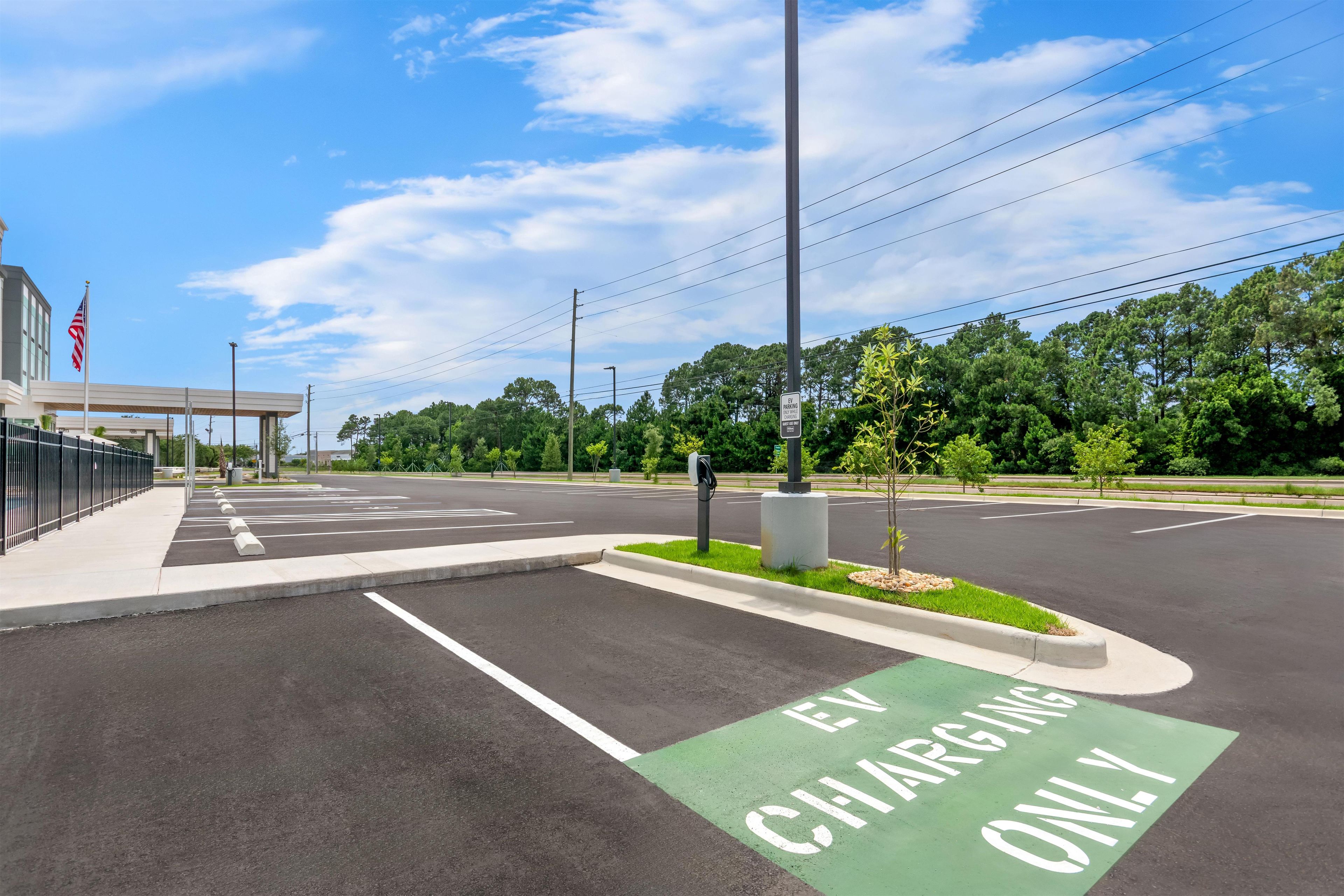 A parking lot with EV charging stations and a green EV-only lane.